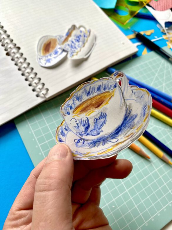 Zeichnung einer Blau weissen Teetasse wird zwischen zwei fingern gehalten