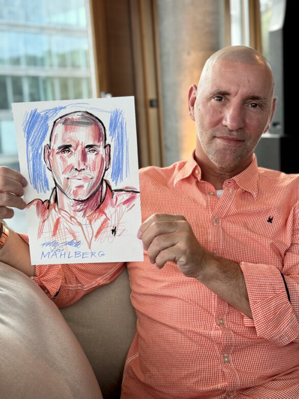 Gast mit farbiger Portraitzeichnung in der Hand beim Event von Juwelier Mahlberg