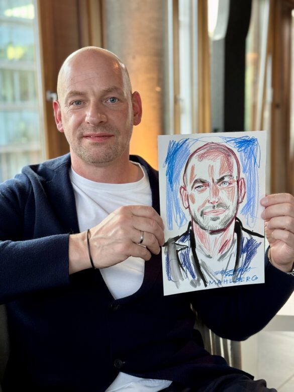 Gast mit farbiger Portraitzeichnung in der Hand beim Event von Juwelier Mahlberg