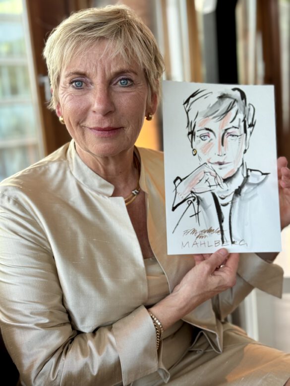 Gast mit farbiger Portraitzeichnung in der Hand beim Event von Juwelier Mahlberg