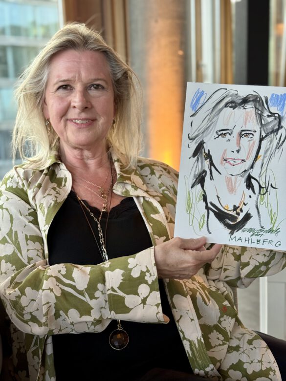 Gast mit farbiger Portraitzeichnung in der Hand beim Event von Juwelier Mahlberg