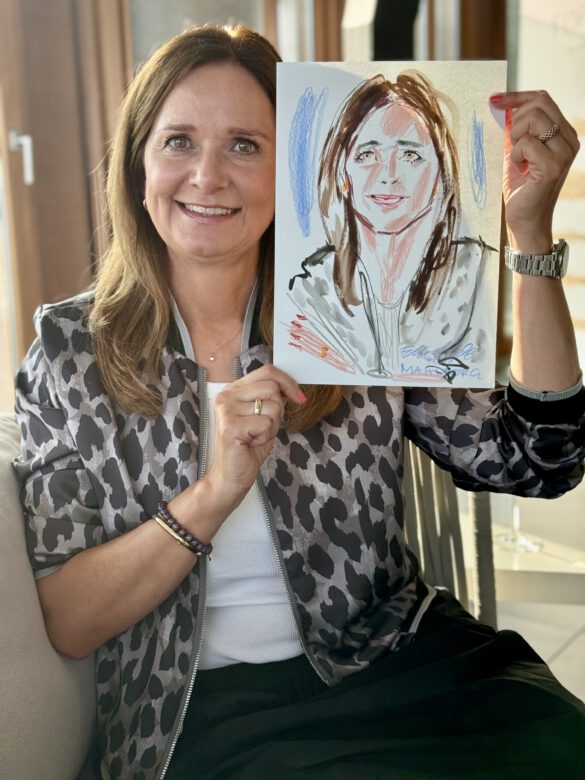 Gast mit farbiger Portraitzeichnung in der Hand beim Event von Juwelier Mahlberg