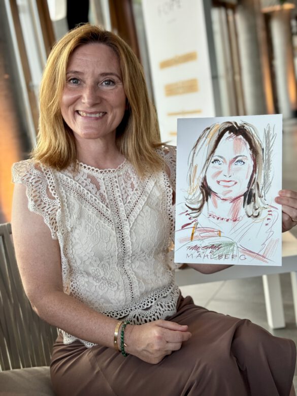 Gast mit farbiger Portraitzeichnung in der Hand beim Event von Juwelier Mahlberg