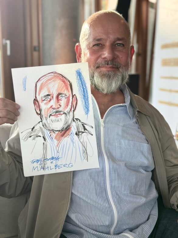 Gast mit farbiger Portraitzeichnung in der Hand beim Event von Juwelier Mahlberg