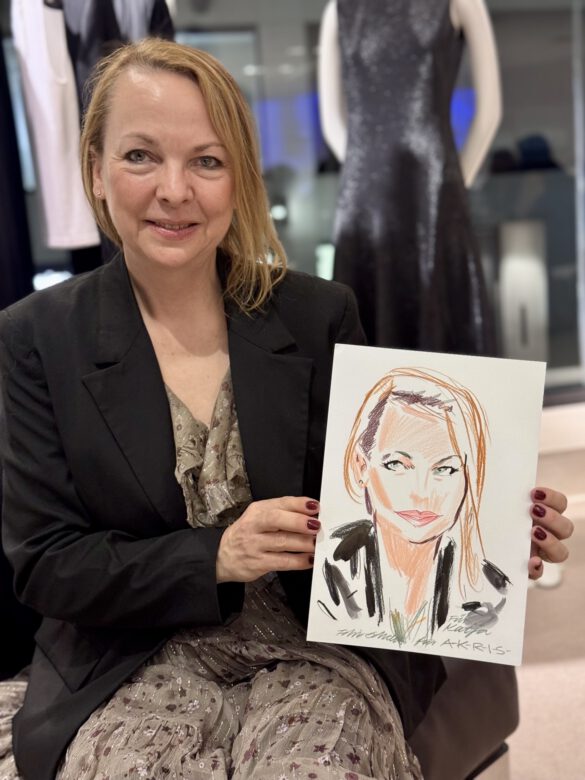 Dame beim AKRIS Dinner in Hamburg, in den Händen eine Portraitzeichnung von ihr von Felix Scholz Illustration