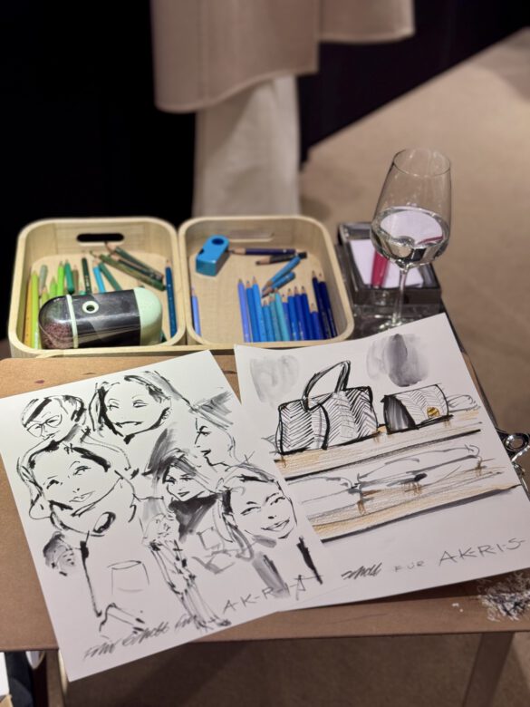 Zeichnungen von Felix Scholz auf einem Tisch mit Zeichenutensilien und einem Weinglas