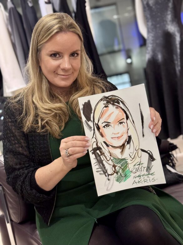 Dame beim AKRIS Dinner in Hamburg, in den Händen eine Portraitzeichnung von ihr von Felix Scholz Illustration