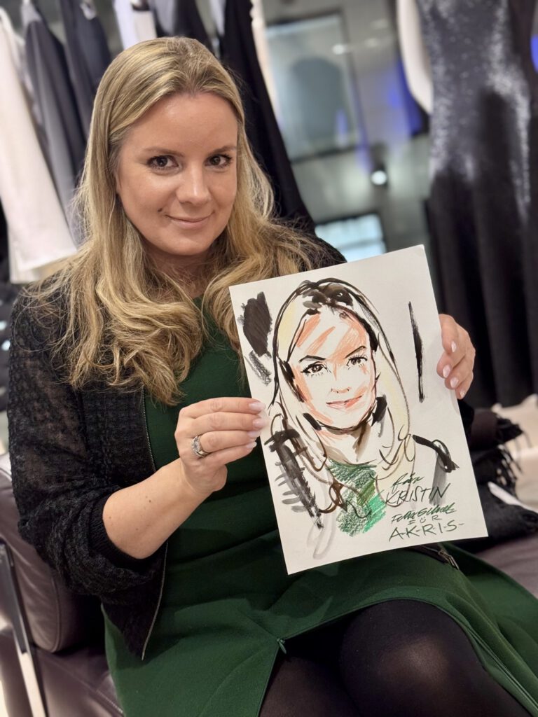 Live Event Illustration: Dame beim AKRIS Dinner in Hamburg, in den Händen eine Portraitzeichnung von ihr von Felix Scholz Illustration