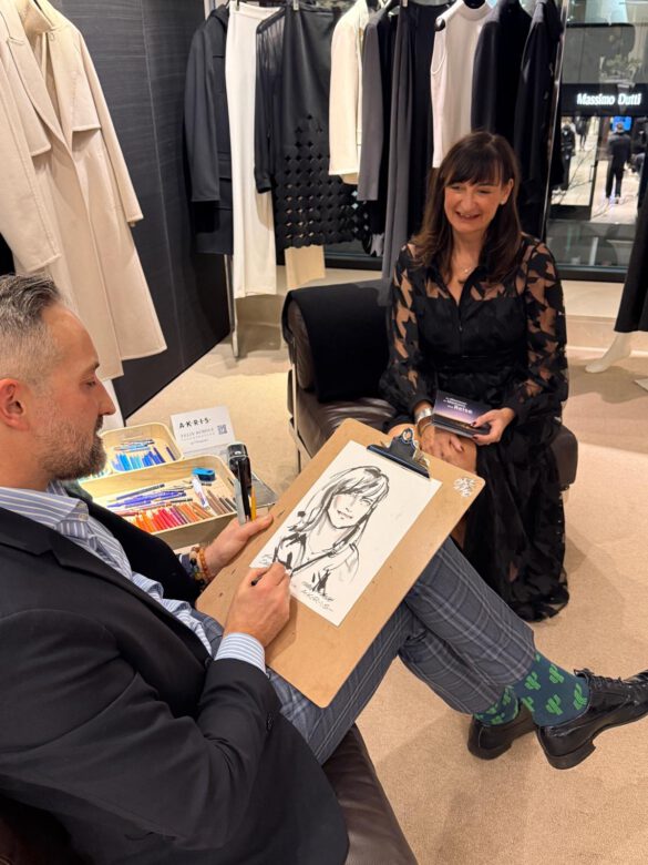 Felix Scholz zeichnet eine Dame in schwarzem Kleid, die beim AKRIS Dinner in Hamburg für ihn Modell sitzt