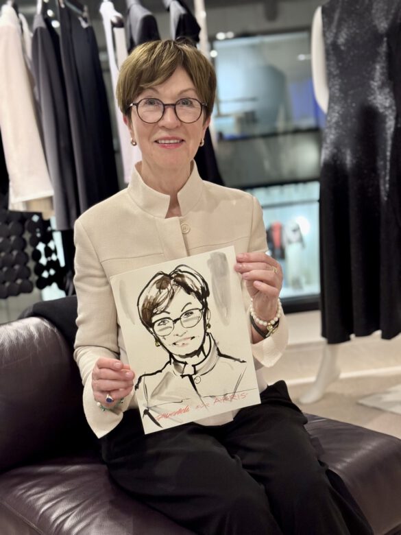 Dame mit Brille beim AKRIS Dinner in Hamburg, in den Händen eine Portraitzeichnung von ihr von Felix Scholz Illustration