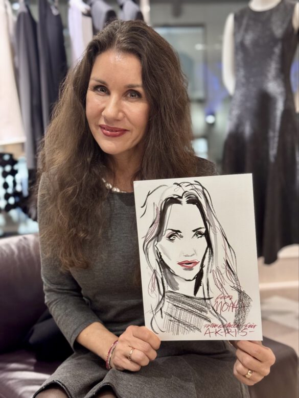 Dame beim AKRIS Dinner in Hamburg, in den Händen eine Portraitzeichnung von ihr von Felix Scholz Illustration