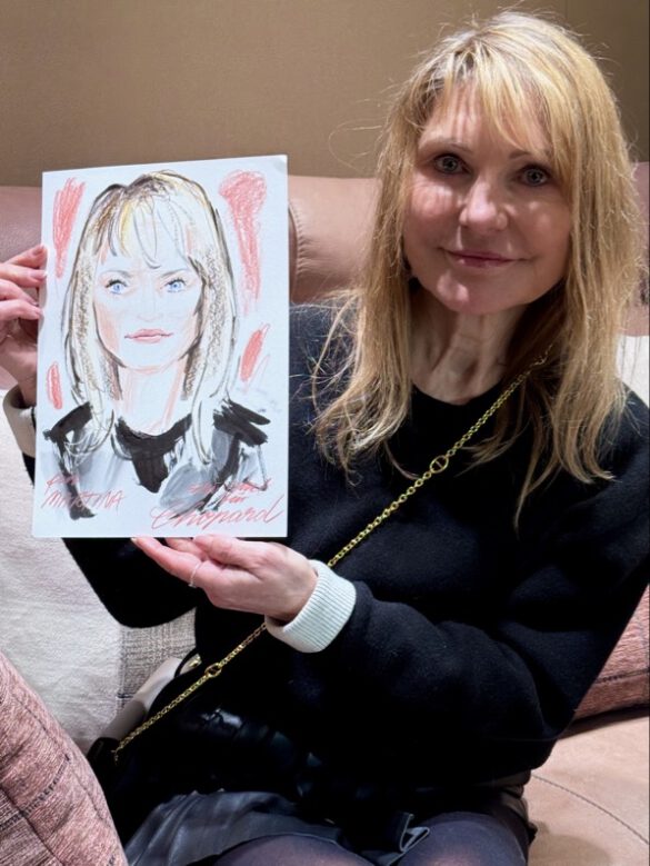 Felix Scholz_Live Event Illustration_Chopard Berlin Kurfürstendamm_10 Eine blonde Dame hält eine farbige Portraitzeichnung des Berliner Künstlers Felix Scholz