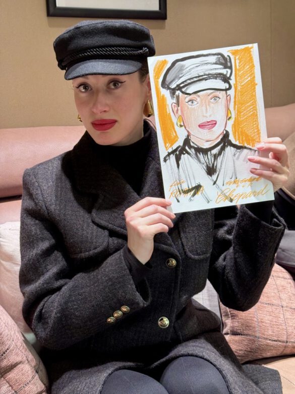 Felix Scholz_Live Event Illustration_Chopard Berlin Kurfürstendamm_11 Eine Dame mit Kapitänsmütze hält eine farbige Portraitzeichnung des Berliner Künstlers Felix Scholz