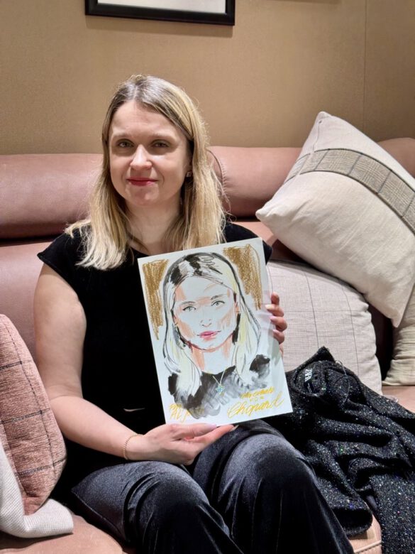 Felix Scholz_Live Event Illustration_Chopard Berlin Kurfürstendamm_6 eine blonde Dame hält eine farbige Portraitzeichnung des Berliner Künstlers Felix Scholz