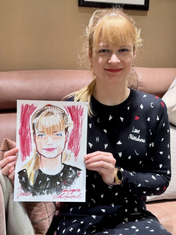 Felix Scholz_Live Event Illustration_Chopard Berlin Kurfürstendamm_8 Eine blonde Dame hält eine farbige Portraitzeichnung des Berliner Künstlers Felix Scholz