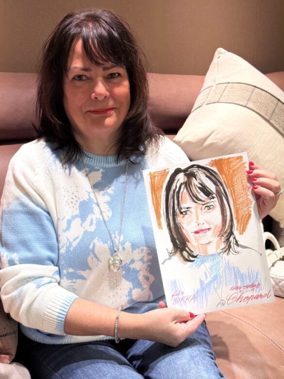 Felix Scholz_Live Event Illustration_Chopard Berlin Kurfürstendamm_9 Eine brünette Dame hält eine farbige Portraitzeichnung des Berliner Künstlers Felix Scholz