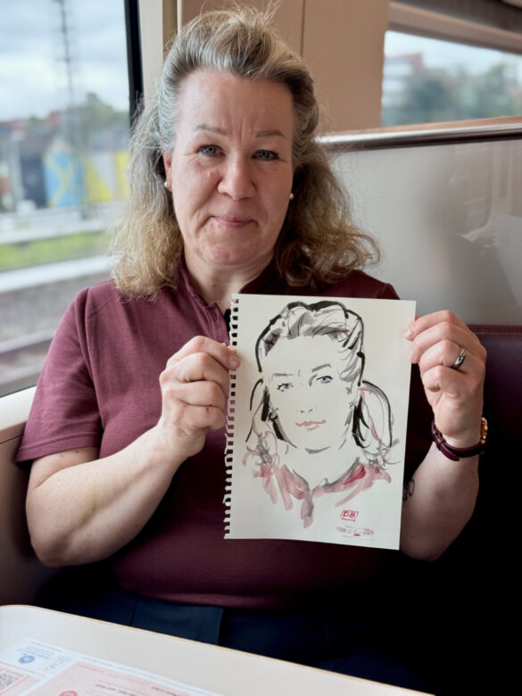 Mitarbeiterin des Deutsche Bahn Bordbistros mit einem live gezeichneten Portrait von Felix Scholz