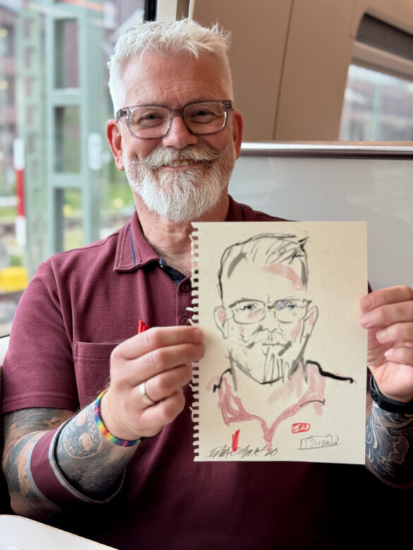 Mitarbeiter des Deutsche Bahn Bordbistros mit einem Portrait das live von Felix Scholz im ICE gezeichnet wurde