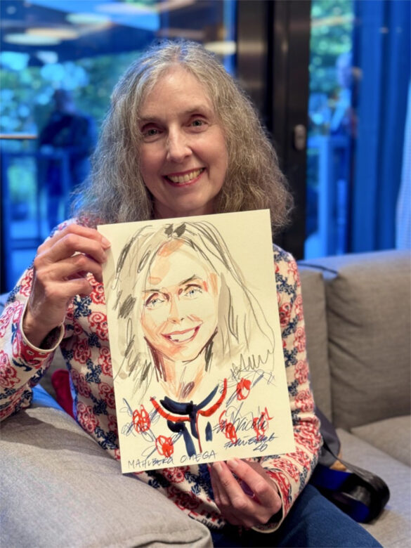 Eine Teilnehmerin der Juwelier Mahlberg + Omega Veranstaltung zeigt ihr handgezeichnetes Portrait, das Felix Scholz während des Events im Hotel Kieler Kaufmann als Live-Illustration angefertigt hat.