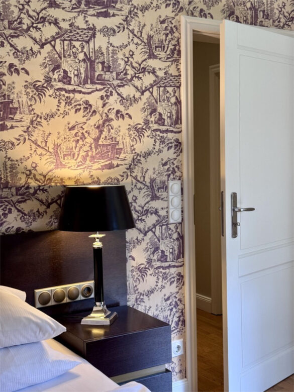 Zimmer im Hotel Kieler Kaufmann, Ansicht des Betts mit einer Chinoiserie Tapete